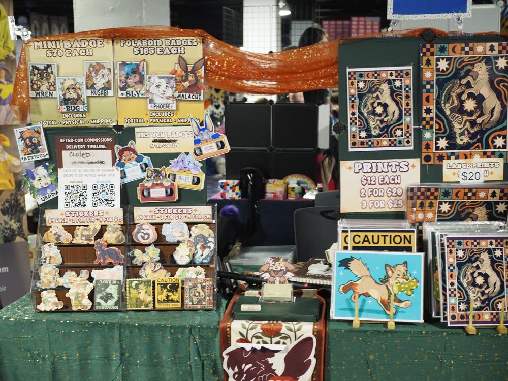 A stand selling their furry themed art as printed matter